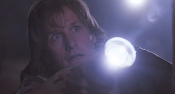 Movie still from “Arachnophobia” (1990), directed by Frank Marshall – A man holding a flashlight up to his face; Close Up shot, Low angle