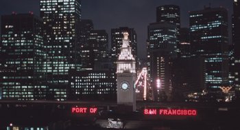 Movie still from “Arachnophobia” (1990), directed by Frank Marshall – A large clock tower in the middle of a large city at night; Extreme Wide shot, High angle