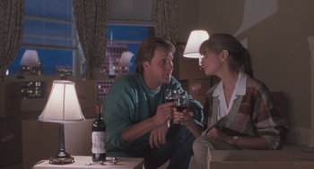 Movie still from “Arachnophobia” (1990), directed by Frank Marshall – A man and a woman sitting on a couch holding wine glasses; Medium shot, High angle