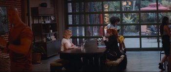 Movie still from “Archenemy” (2020), directed by Adam Egypt Mortimer – Two women sitting at a table in front of each other; Wide shot, Over the shoulder angle