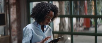 Movie still from “Archenemy” (2020), directed by Adam Egypt Mortimer – A woman is holding a tablet in her hands; Close Up shot, Over the shoulder angle