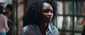 Movie still from “Archenemy” (2020), directed by Adam Egypt Mortimer – A person with curly hair; Close Up shot, Over the shoulder angle