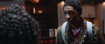 Movie still from “Archenemy” (2020), directed by Adam Egypt Mortimer – A man in a brown jacket is standing in front of a woman; Close Up shot, Over the shoulder angle