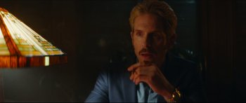 Movie still from “Archenemy” (2020), directed by Adam Egypt Mortimer – A person wearing a suit and tie; Close Up shot, Over the shoulder angle