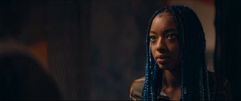 Movie still from “Archenemy” (2020), directed by Adam Egypt Mortimer – A young woman with blue braids is looking at the camera; Close Up shot, Over the shoulder angle