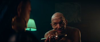 Movie still from “Archenemy” (2020), directed by Adam Egypt Mortimer – A man with a bald head is brushing his teeth in front of a mirror; Close Up shot, Over the shoulder angle