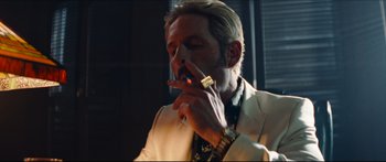 Movie still from “Archenemy” (2020), directed by Adam Egypt Mortimer – A man in a white suit smoking a cigarette; Close Up shot, Low angle