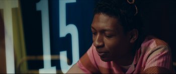 Movie still from “Archenemy” (2020), directed by Adam Egypt Mortimer – A young man sitting in front of a number 5 sign; Close Up shot, Over the shoulder angle