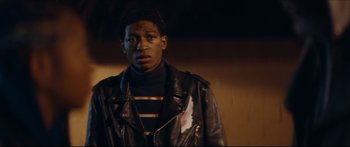 Movie still from “Archenemy” (2020), directed by Adam Egypt Mortimer – A man in a leather jacket looking at the camera; Close Up shot, Low angle