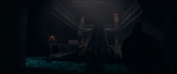 Movie still from “Archenemy” (2020), directed by Adam Egypt Mortimer – Two escalators going down the side of a building; Extreme Wide shot, Low angle