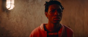 Movie still from “Archenemy” (2020), directed by Adam Egypt Mortimer – A young man with dreadlocks is looking at the camera; Close Up shot, Low angle