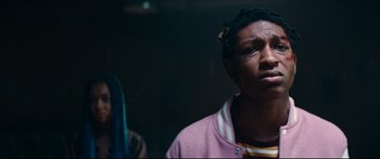 Movie still from “Archenemy” (2020), directed by Adam Egypt Mortimer – Two people standing next to each other in a dark room; Close Up shot, Low angle