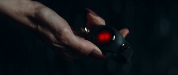 Movie still from “Archenemy” (2020), directed by Adam Egypt Mortimer – A person holding a remote control in their hand; Extreme Close Up shot, Overhead angle