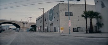 Movie still from “Archenemy” (2020), directed by Adam Egypt Mortimer – A building with a large clock on the side of the building; Extreme Wide shot, High angle