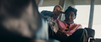 Movie still from “Archenemy” (2020), directed by Adam Egypt Mortimer – Two people sitting on a bus playing a guitar; Close Up shot, Over the shoulder angle