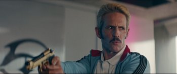 Movie still from “Archenemy” (2020), directed by Adam Egypt Mortimer – A man holding a banana in his right hand; Close Up shot, Low angle