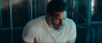 Movie still from “Archenemy” (2020), directed by Adam Egypt Mortimer – A person wearing a white t - shirt; Medium shot, Over the shoulder angle