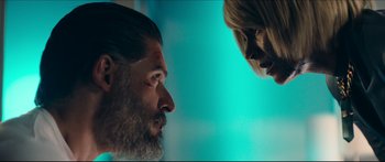 Movie still from “Archenemy” (2020), directed by Adam Egypt Mortimer – A man and a woman looking at one another; Close Up shot, Over the shoulder angle