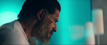 Movie still from “Archenemy” (2020), directed by Adam Egypt Mortimer – A person with a beard; Close Up shot, Over the shoulder angle