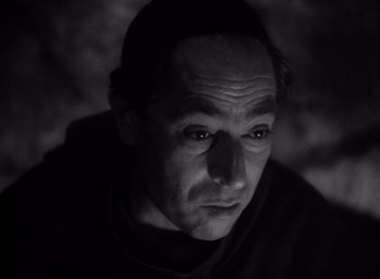 Movie still from “Arise, My Love” (1940), directed by Mitchell Leisen – Black and white photograph of a man in a black shirt; Close Up shot, High angle