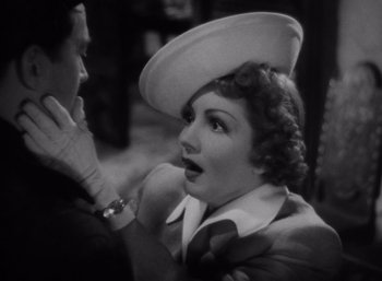 Movie still from “Arise, My Love” (1940), directed by Mitchell Leisen – An old black and white photo of a woman wearing a hat; Close Up shot, Over the shoulder angle