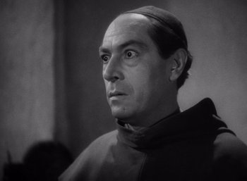 Movie still from “Arise, My Love” (1940), directed by Mitchell Leisen – A black - and - white photo of a man in a priest's outfit; Close Up shot, Low angle