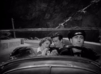 Movie still from “Arise, My Love” (1940), directed by Mitchell Leisen – A man and a woman sitting in the drivers seat of a car; Medium shot, High angle