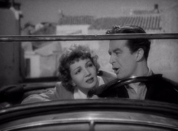 Movie still from “Arise, My Love” (1940), directed by Mitchell Leisen – A man and a woman in the back seat of a car; Medium shot, High angle