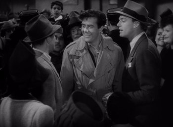 Movie still from “Arise, My Love” (1940), directed by Mitchell Leisen – A black and white photo of a group of men talking; Medium shot, Over the shoulder angle