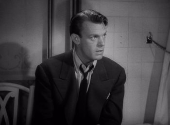 Movie still from “Arise, My Love” (1940), directed by Mitchell Leisen – A black and white photo of a man wearing a suit and tie; Close Up shot, Low angle