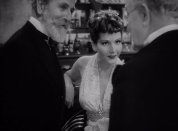 Movie still from “Arise, My Love” (1940), directed by Mitchell Leisen – A man and a woman standing next to each other in front of another man; Medium shot, Over the shoulder angle