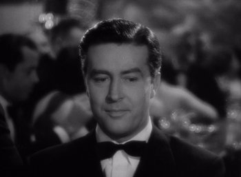 Movie still from “Arise, My Love” (1940), directed by Mitchell Leisen – A black and white photo of a man in a tuxedo; Close Up shot, Over the shoulder angle