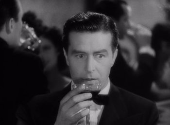 Movie still from “Arise, My Love” (1940), directed by Mitchell Leisen – A black and white photo of a man drinking a glass of red wine; Close Up shot, High angle