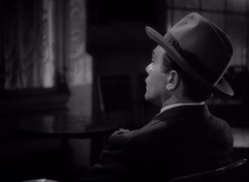 Movie still from “Arise, My Love” (1940), directed by Mitchell Leisen – A black and white photo of a man wearing a hat; Close Up shot, High angle