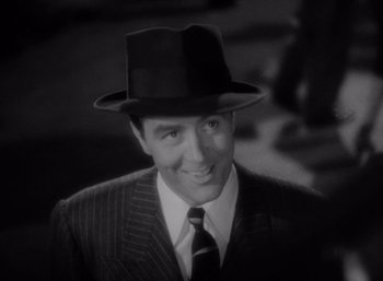 Movie still from “Arise, My Love” (1940), directed by Mitchell Leisen – A black and white photo of a man in a suit and a hat; Close Up shot, High angle