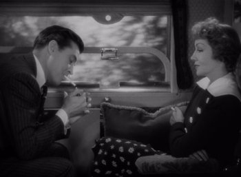 Movie still from “Arise, My Love” (1940), directed by Mitchell Leisen – A man and a woman sitting on a train; Medium shot, High angle