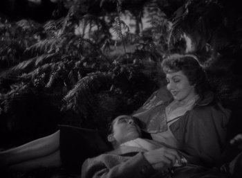 Movie still from “Arise, My Love” (1940), directed by Mitchell Leisen – A woman sitting next to a man on a bench; Medium shot, High angle
