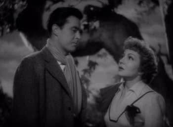 Movie still from “Arise, My Love” (1940), directed by Mitchell Leisen – A man and a woman standing next to each other in front of a tree; Medium shot, Low angle