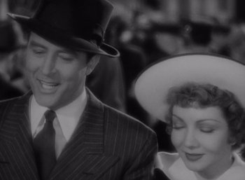 Movie still from “Arise, My Love” (1940), directed by Mitchell Leisen – A man and a woman wearing hats and suits; Close Up shot, Over the shoulder angle