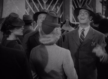 Movie still from “Arise, My Love” (1940), directed by Mitchell Leisen – A group of men and women in suits and hats; Medium shot, Low angle