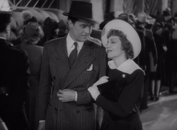 Movie still from “Arise, My Love” (1940), directed by Mitchell Leisen – A man and a woman standing next to each other; Medium shot, Low angle