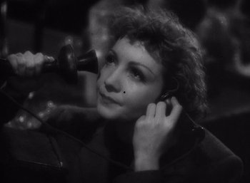 Movie still from “Arise, My Love” (1940), directed by Mitchell Leisen – A black - and - white photo of a woman blow drying her hair; Close Up shot, High angle