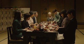 A group of people sitting around a table eating food