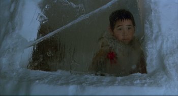 Movie still from “Arizona Dream” (1993), directed by Emir Kusturica – A young boy is looking out of a window; Medium shot, High angle