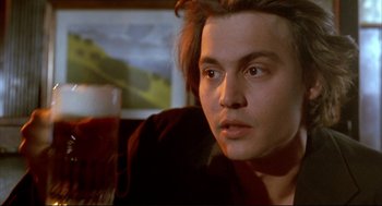 Movie still from “Arizona Dream” (1993), directed by Emir Kusturica – A man sitting in front of a glass of beer; Close Up shot, Over the shoulder angle