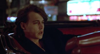 Movie still from “Arizona Dream” (1993), directed by Emir Kusturica – A man sitting on a couch in a room; Close Up shot, High angle