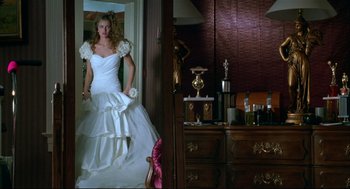 Movie still from “Arizona Dream” (1993), directed by Emir Kusturica – A woman in a wedding dress standing in front of a dresser; Wide shot, Low angle