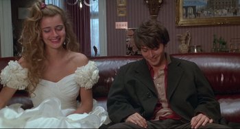 Movie still from “Arizona Dream” (1993), directed by Emir Kusturica – A man and a woman sitting on a couch in front of a window; Medium shot, Over the shoulder angle