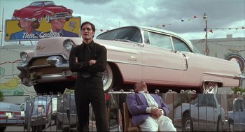 Movie still from “Arizona Dream” (1993), directed by Emir Kusturica – A man standing in front of an old pink car; Wide shot, Low angle