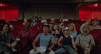 Movie still from “Arizona Dream” (1993), directed by Emir Kusturica – A group of people sitting in a movie theater; Wide shot, High angle